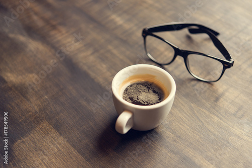 cup of coffee and glasses on table