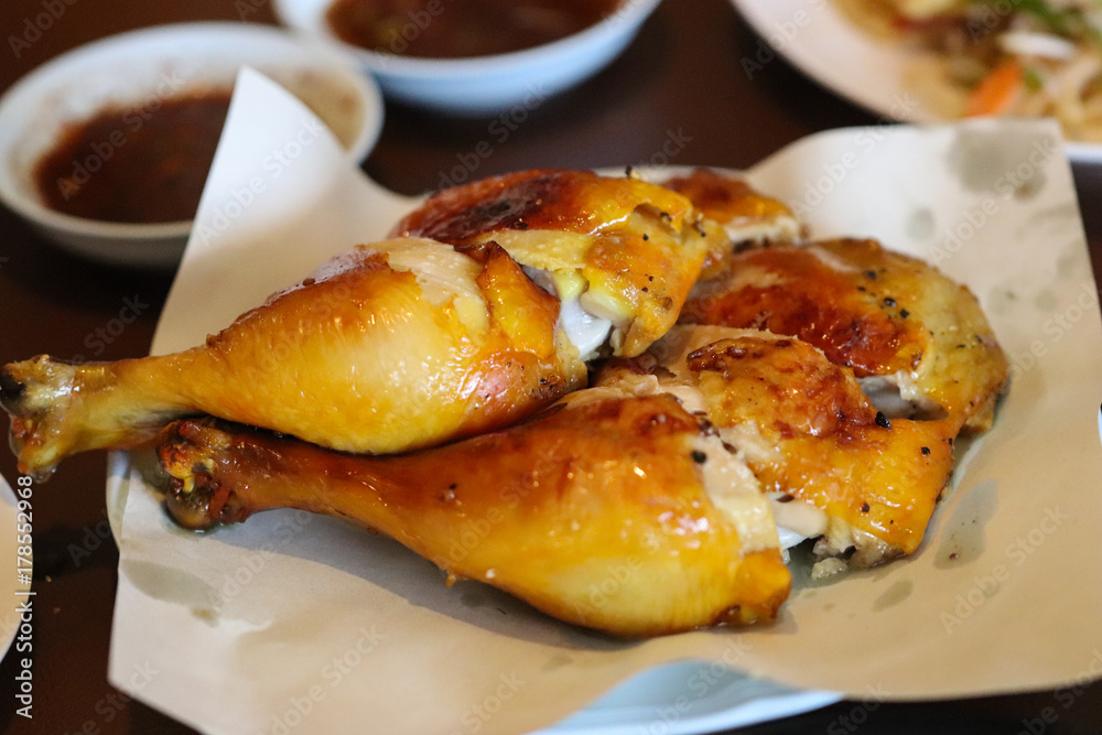 Chicken Grilled and black pepper with spicy sauce. Popular food in Thailand, It is yellowish from grilling or baking.