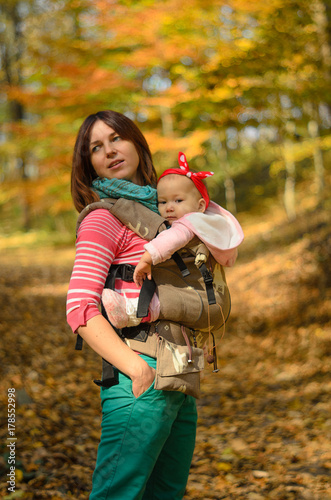 Obraz na płótnie Mother carrying her baby daughter in ergonomic backpack for children w salonie