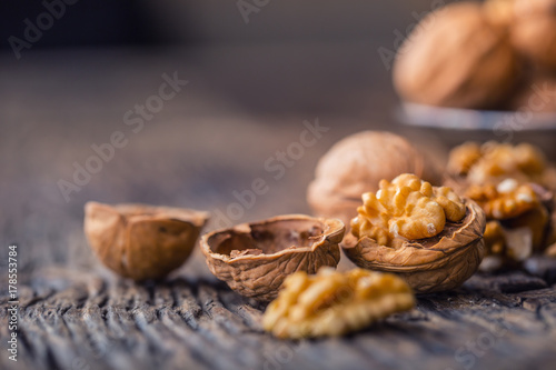 Walnut. Walnut kernels and whole walnuts on rustic old oak table