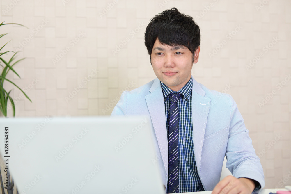 ノートパソコンで仕事中のビジネスマン