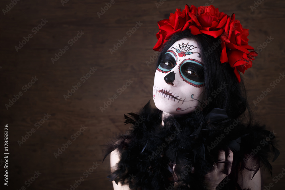 Day of the dead. Halloween. Young woman in day of the dead mask skull face art and rose. Dark background. Day of the dead. Halloween. Young woman in day of the dead mask skull face art and rose. Dark background.
