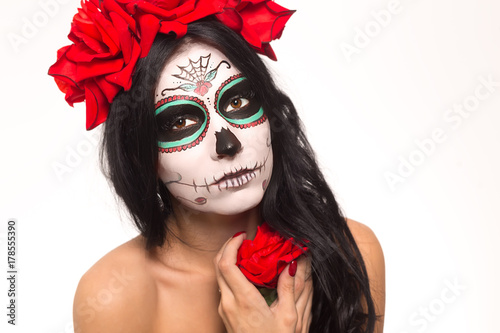 Fototapeta Naklejka Na Ścianę i Meble -  Day of the dead. Halloween. Young woman in day of the dead mask skull face art and rose. Isolated on white. closeup.