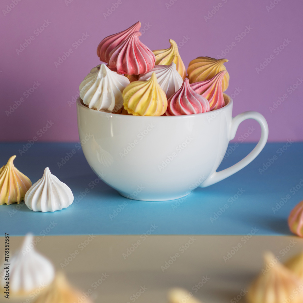 Dessert with meringue, a lot of colorful meringues in the tea Cup Dessert with meringue, a lot of colorful meringues in the tea Cup