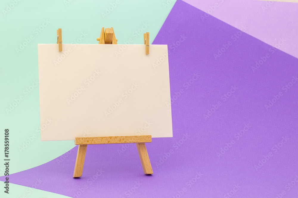 +White paper on little easel on colorful background +White paper on little easel on colorful background