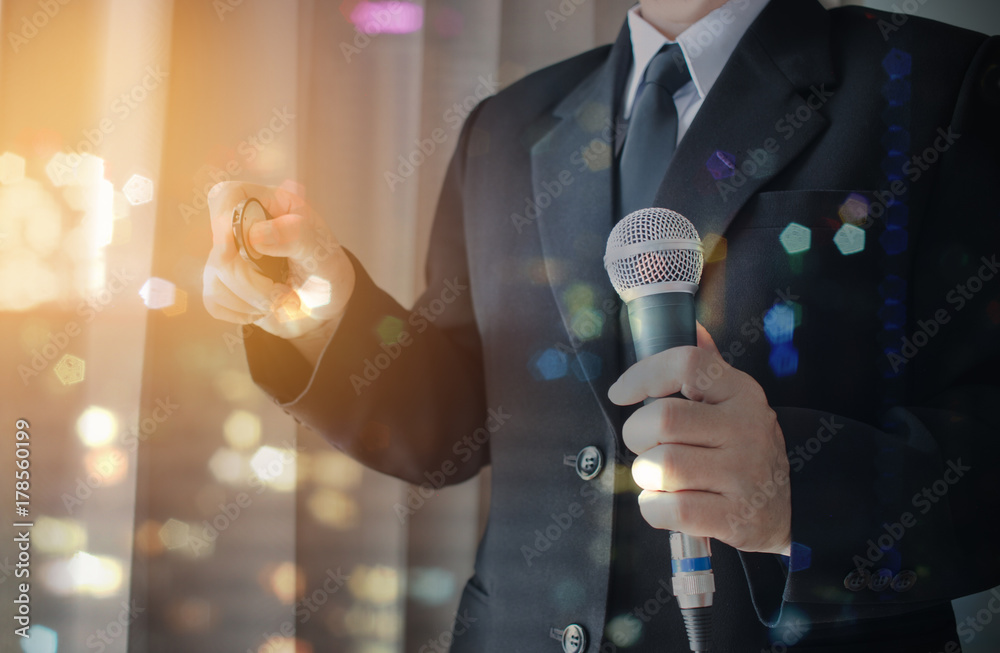 Φωτογραφία Businessman speaking with microphones in public meeting room at conference hall, hands holding mouse pointing over Abstract blur background