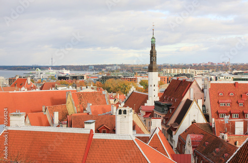 Scenic Cityscape of Tallinn, capital of Estonia. Top view of Old Town area, overlooking historical european buildings with famous red rooftops tiles. Vivid wallpaper, cloudy sky background copy space.