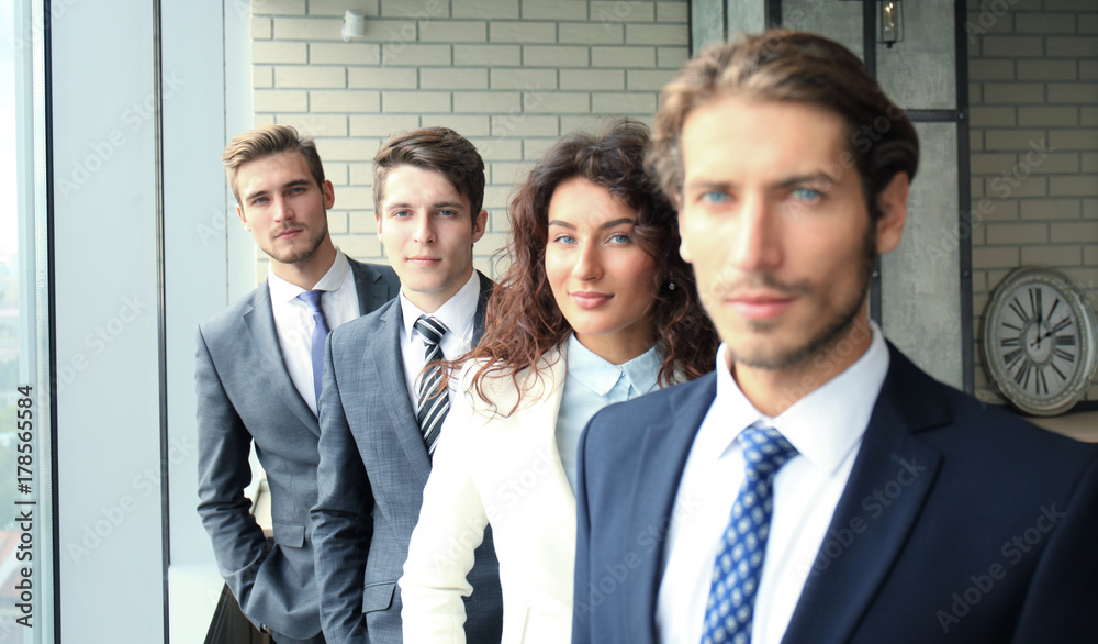Happy smiling business team standing in a row at office. Happy smiling business team standing in a row at office.