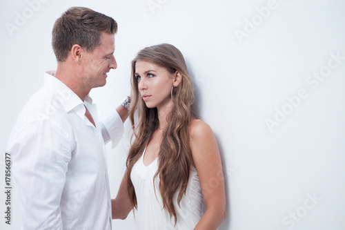 portrait of nice young couple on white wall background