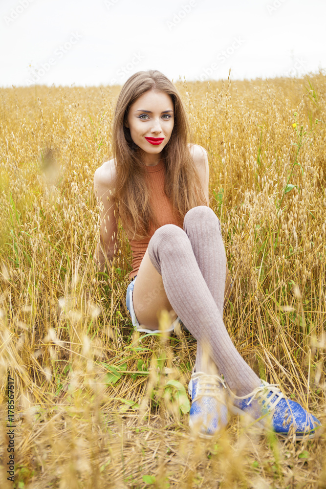 Young beautiful woman walking in a field, summer outdoors Young beautiful woman walking in a field, summer outdoors
