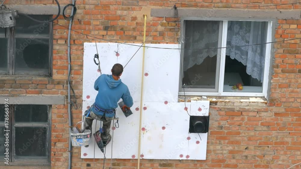 Industrial alpinism. The work on the outer Insulate of an apartment house Industrial alpinism. The work on the outer Insulate of an apartment house