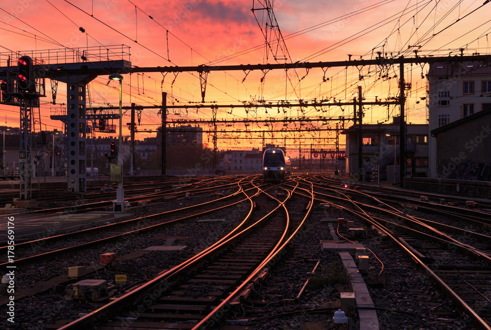 Obraz premium Pociąg na torach kolejowych podczas wschodu słońca. Gare de Lyon-Perrache, Lyon, Francja.