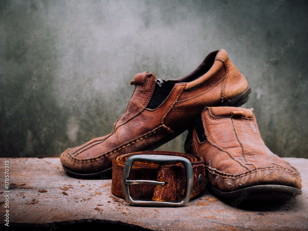 Still life old Leather shoes and belt. It more of dirty and shabby skin.  Time to change new shoes or repair. Photos | Adobe Stock