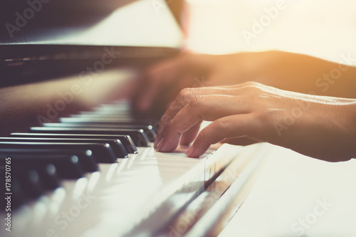 Fotografia Close up of happy woman's hand playing the piano in the morning.