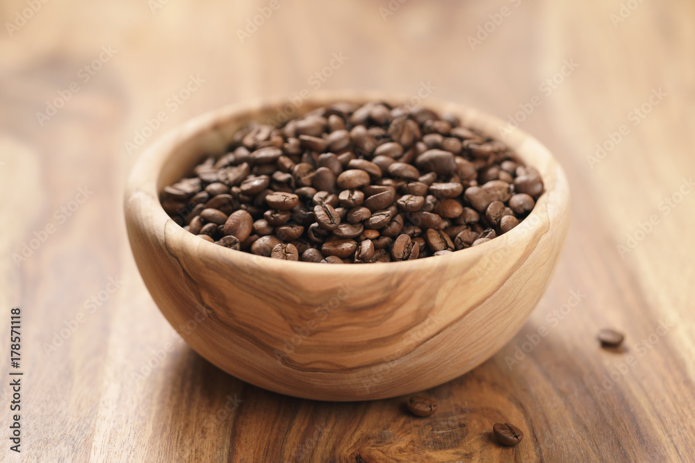 roasted coffee beans in wood bowl on table roasted coffee beans in wood bowl on table