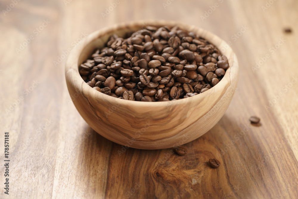 roasted coffee beans in wood bowl on table roasted coffee beans in wood bowl on table