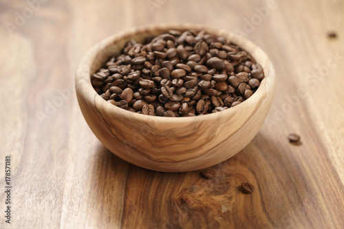 roasted coffee beans in wood bowl on table