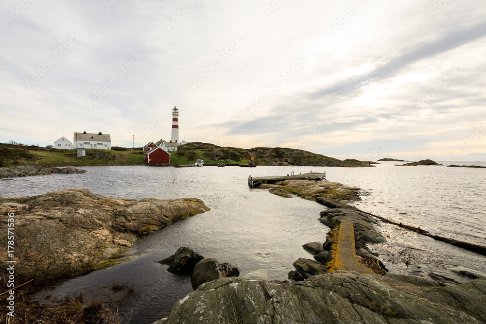 A small pier and the lighthouse at Oksoy, Kristiansand in Norway.