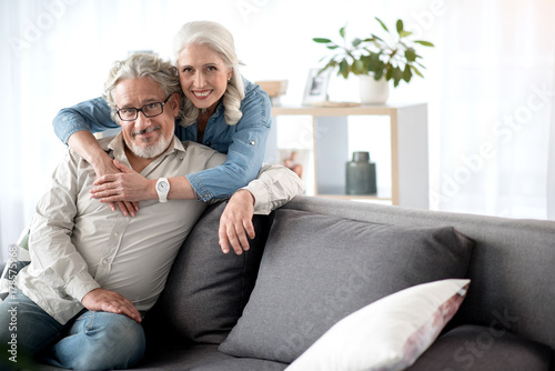 Cheerful mature husband and wife resting in living room