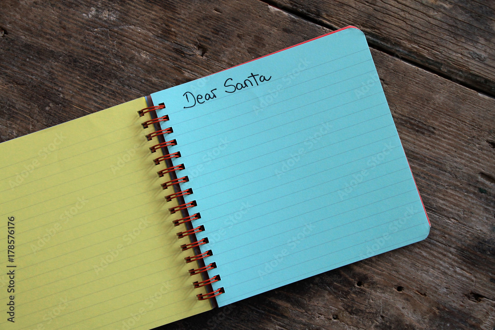 Letter to Santa Claus in colorful notebook on wooden table