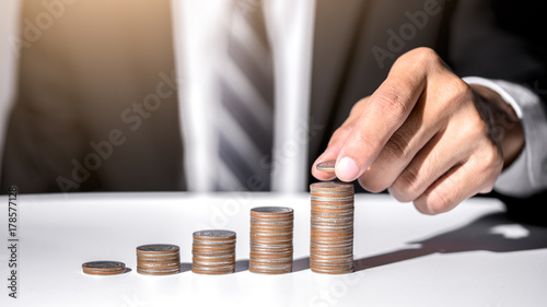 Hand of male putting gold coin stack, Finance and investment save money concept