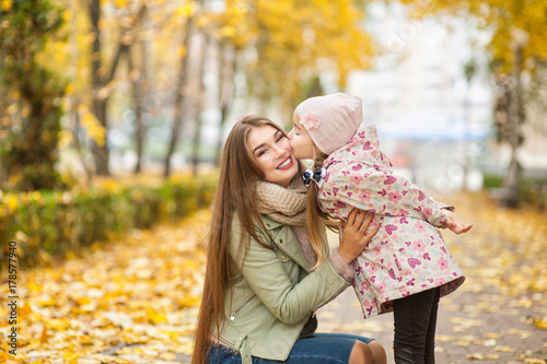 .Beautiful mom with a daughter are walking in a autumn forest or park, mother's day