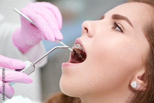 Cropped close up of a female patient being examined by a professional dentist at the dental clinic health healthcare medicine clinical treatment procedure profession occupation service concept.