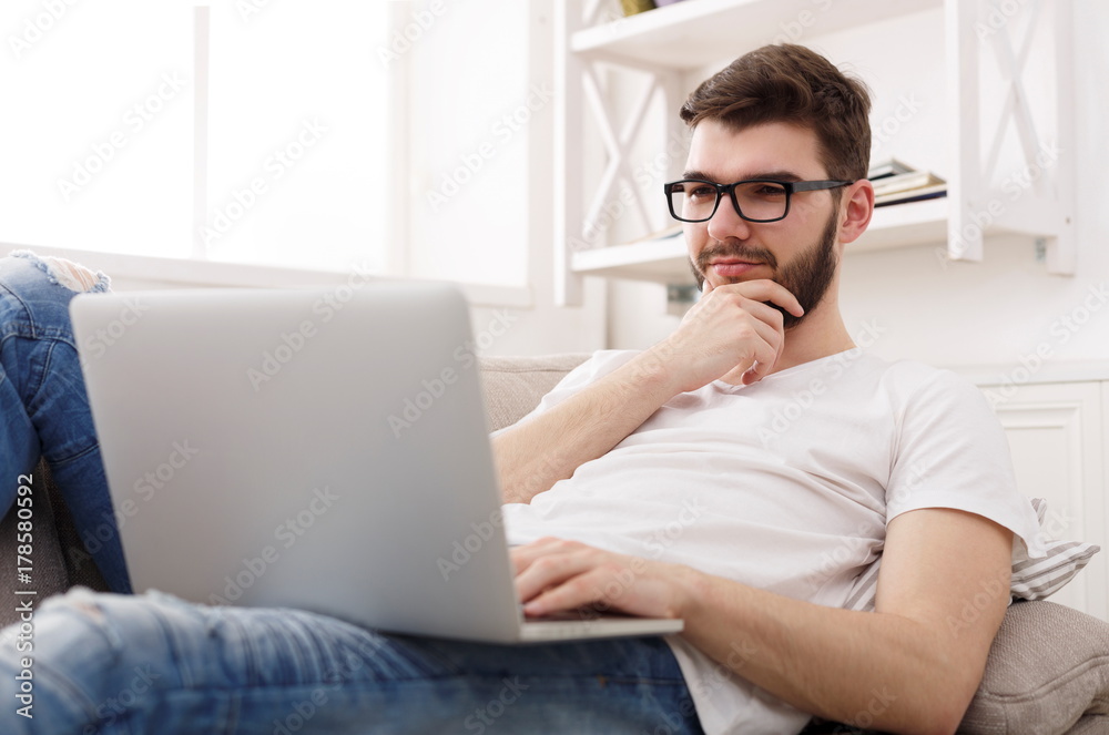Young man at home messaging online on laptop Young man at home messaging online on laptop