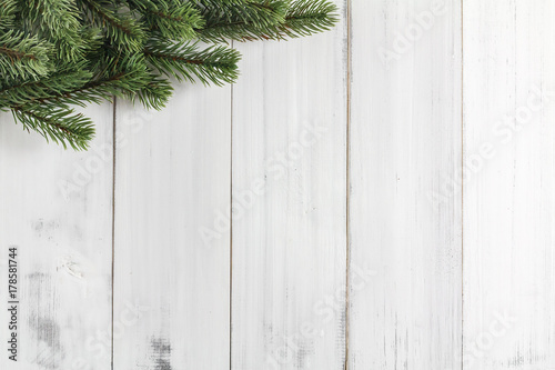 Christmas fir tree branches on white rustic wooden background with copy space for text