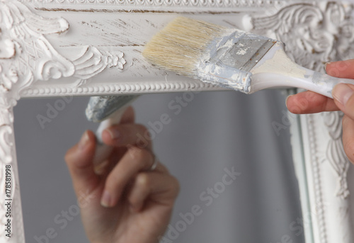 Diy woman painting, renewing mirror frame at home. photo