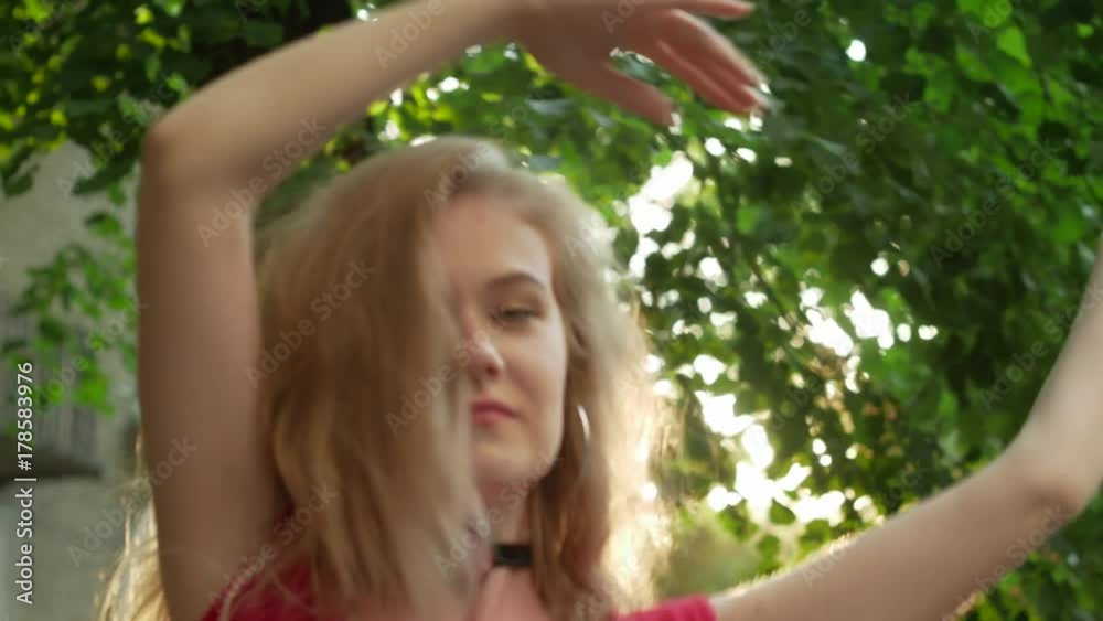 Blond hair beautiful girl dancing at the street summer day Blond hair beautiful girl dancing at the street summer day