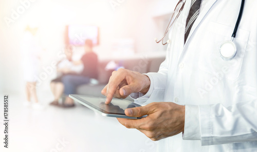 Smart health care internet of things and hospital automation management technology concept with paperless. Doctor with Stethoscope using tablet for remote monitoring to check status of patient. photo