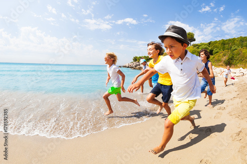 Kids run a race in shallow sea water