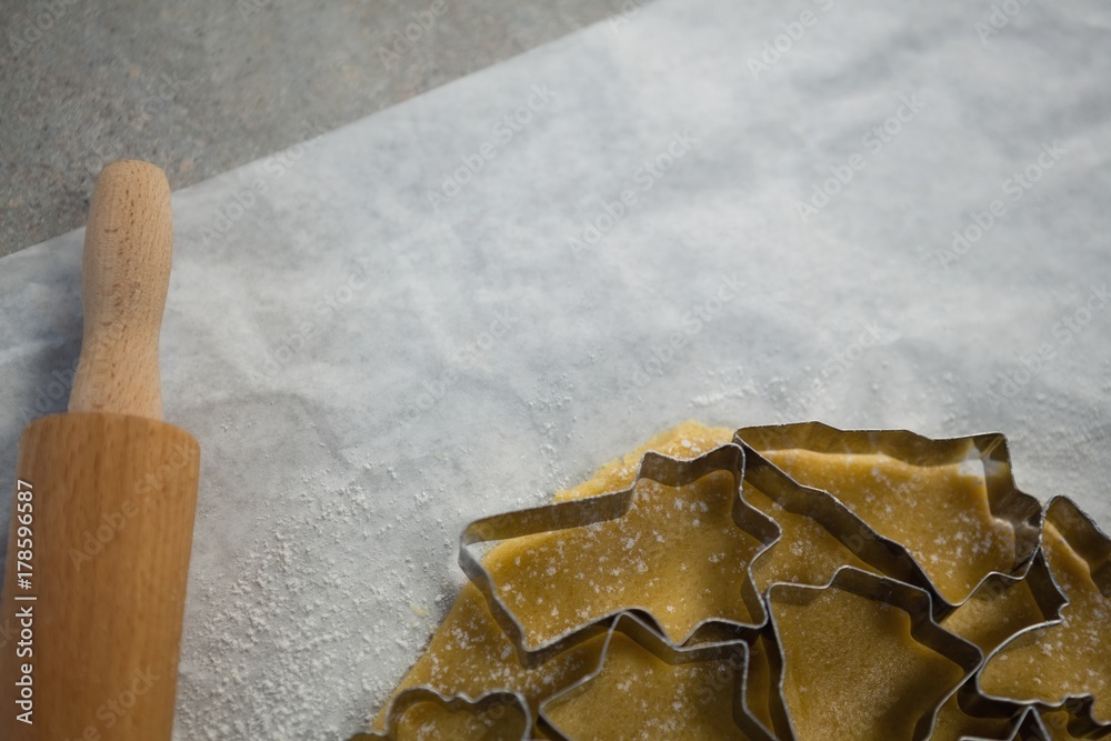 Cropped image of various pastry cutters over dough on wax paper Cropped image of various pastry cutters over dough on wax paper