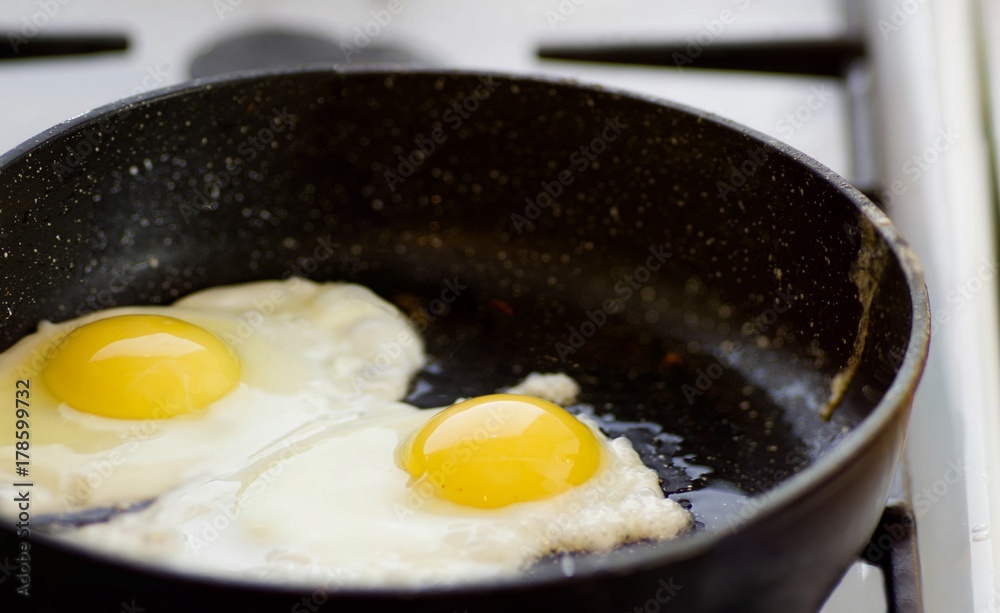 panorama of fried eggs in a frying pan, two pieces panorama of fried eggs in a frying pan, two pieces