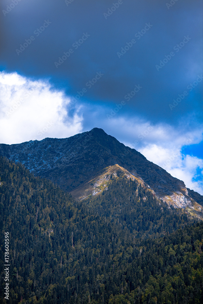 large dense mountain against a blue sky with clouds