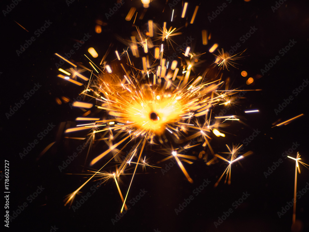 Fototapeta premium The bright stream of a sparks on the black background