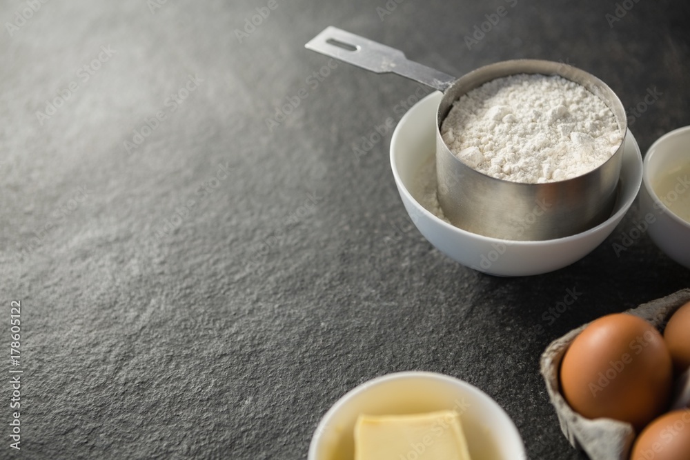 Close up of flour in measuring cup by ingredients Close up of flour in measuring cup by ingredients