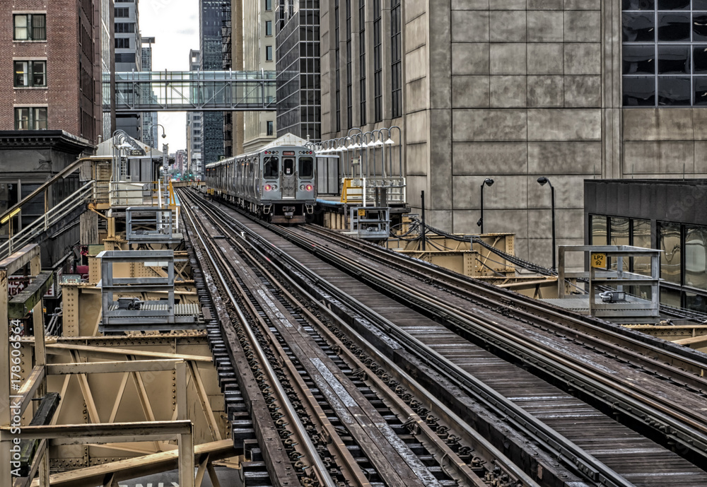 Naklejka premium Train on elevated tracks within buildings at the Loop, Chicago City Center - Dark Deep Tonal Artistic Effect - Chicago, Illinois, USA