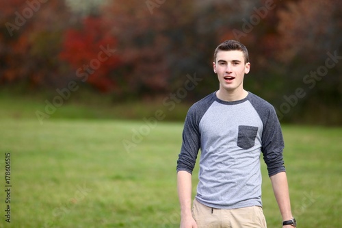 Portrait of a teenage boy walking outdoors during autumn