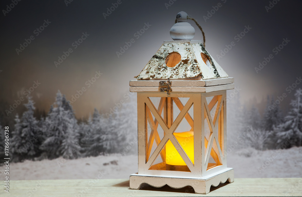 christmas lantern and snowy firs in the background