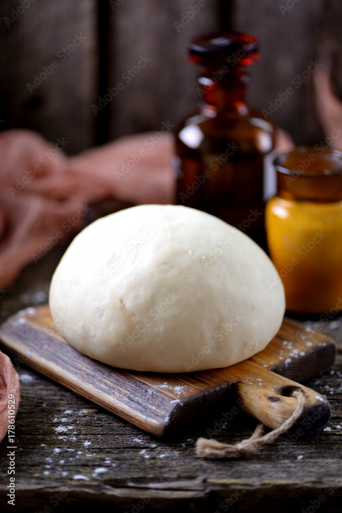 Fototapeta premium Dough with yeast from wheat flour with olive oil for pizza and homemade bread.