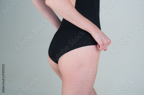 buttocks of young girl in black swimsuit