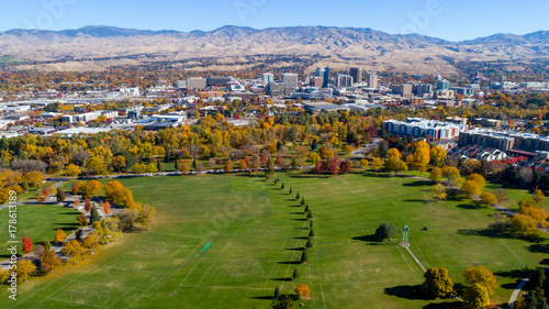 City park with trees in autumn along with the skyline of Boise