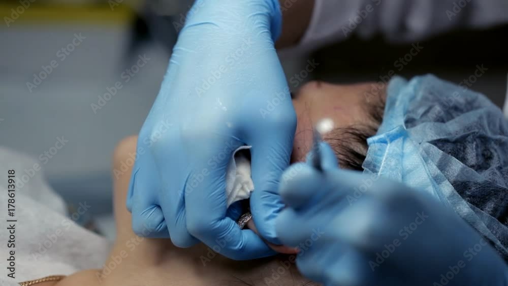 The beautician clears the girl's ears during facial cleansing The beautician clears the girl's ears during facial cleansing