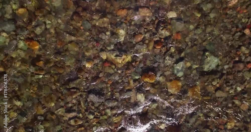 Aerial UHD 4K view. Mid-air flight over fresh and clean mountain river with transparent water and stone river bed at sunny summer morning. Top view and horizontal movement Aerial UHD 4K view. Mid-air flight over fresh and clean mountain river with transparent water and stone river bed at sunny summer morning. Top view and horizontal movement