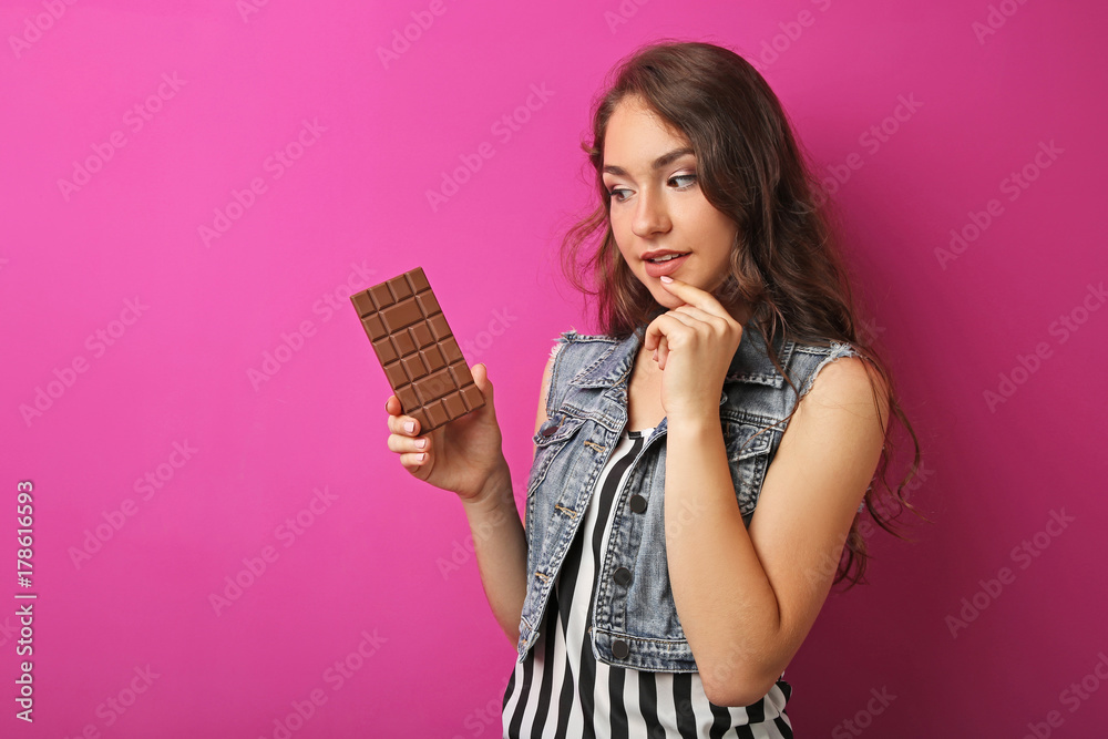 Portrait of young woman with chocolate bar on pink background Portrait of young woman with chocolate bar on pink background