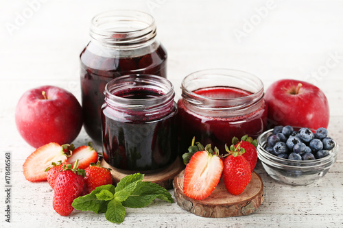 Wallpaper Mural Glass jars with different kinds of jam on wooden table Torontodigital.ca