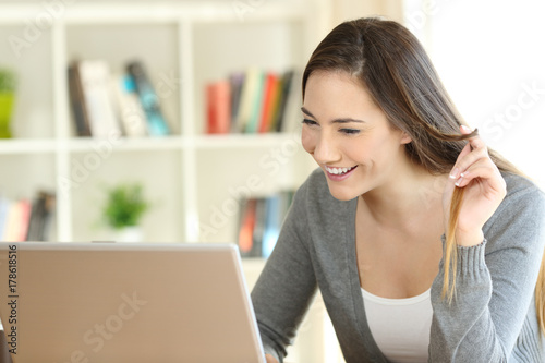 Candid girl dating on line with a laptop at home