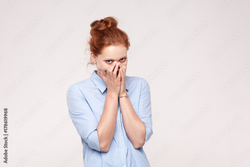 Shame and liar concept. Red haired woman covering mouth with both hands keeping a secret and little smiling. Shame and liar concept. Red haired woman covering mouth with both hands keeping a secret and little smiling.